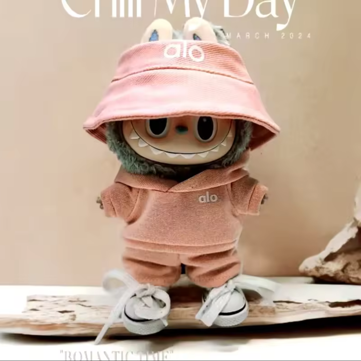 Stuffed toy in pink outfit with matching hat on a beige background